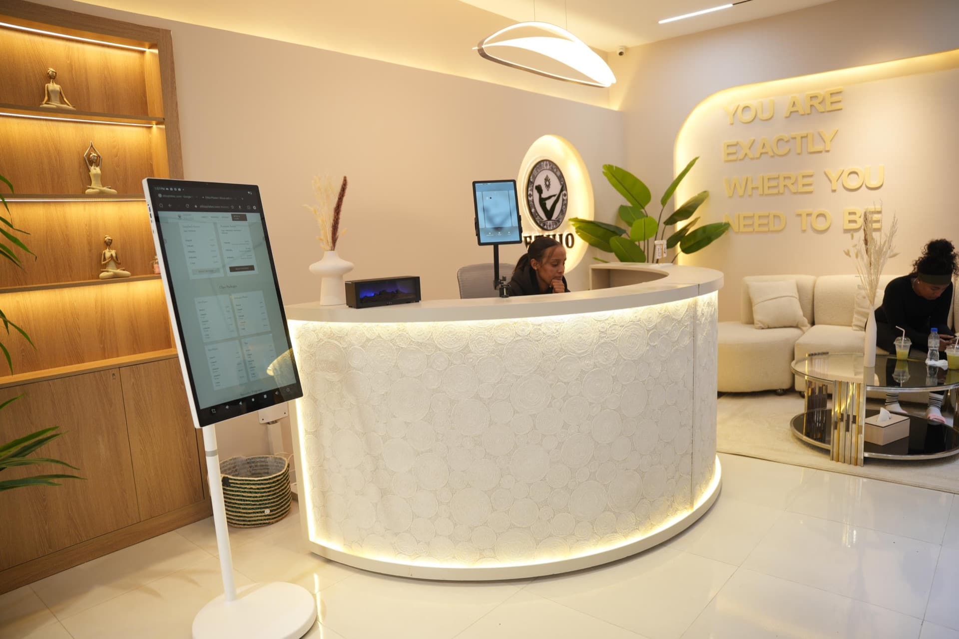 The studio reception, where brass letters on the wall read 'You are exactly where you need to be'